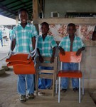 drie jongens van de Clarkschool met hun nieuwe stoelen
