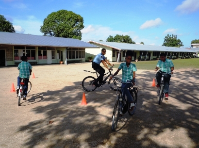 veilig fietsen: leerlingen en biker op het schoolplein